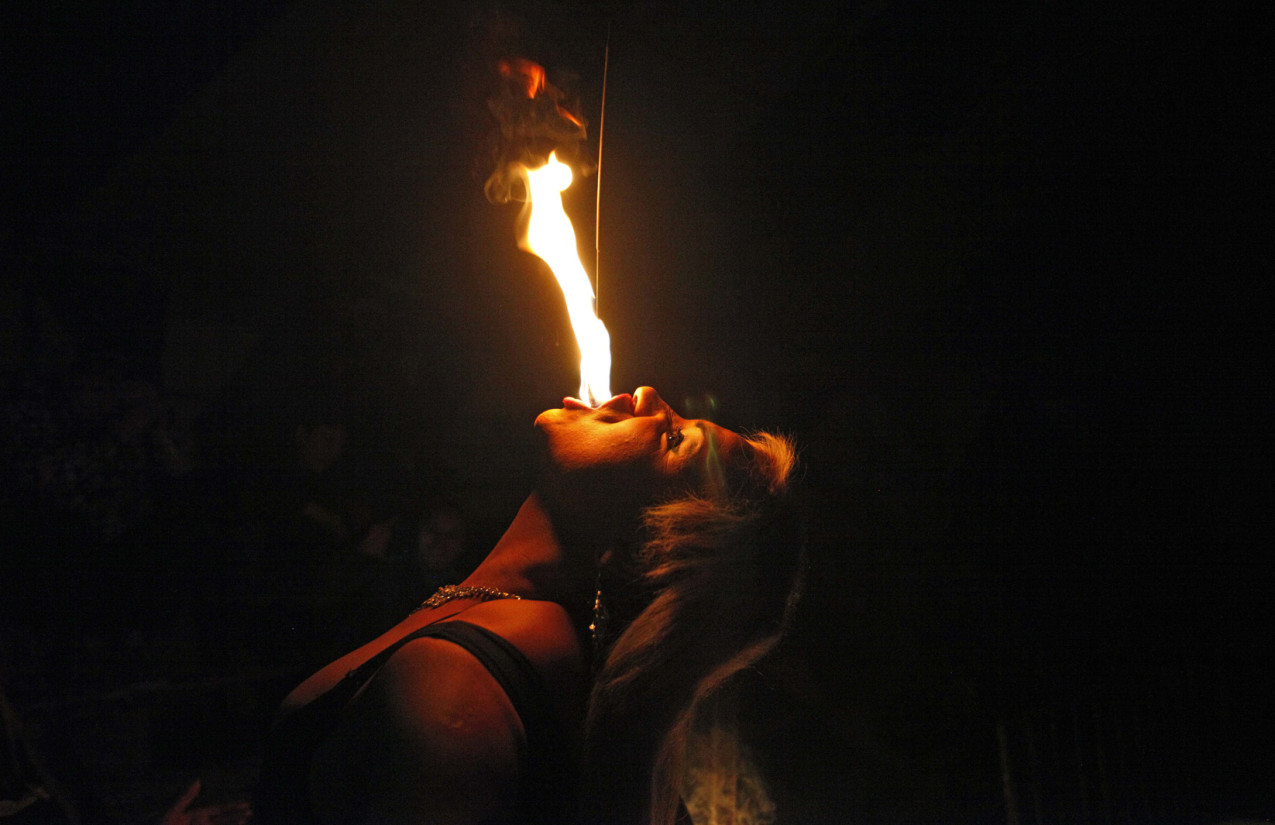 In this July 7, 2013 photo, drag queen Susan Brown spits fire during her performance in the "Fama" circus show in Santiago, Chile.  The only classic circus act in Fama is Brown's fire eating performance.  Fama has toured the country for more than a decade performing in modest tents and they say their show remains a refuge from discrimination. Chile has traditionally been a tough place for homosexuals. (AP Photo/Luis Hidalgo)