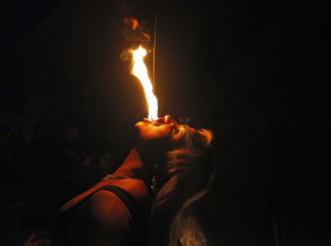 In this July 7, 2013 photo, drag queen Susan Brown spits fire during her performance in the "Fama" circus show in Santiago, Chile.  The only classic circus act in Fama is Brown's fire eating performance.  Fama has toured the country for more than a decade performing in modest tents and they say their show remains a refuge from discrimination. Chile has traditionally been a tough place for homosexuals. (AP Photo/Luis Hidalgo)