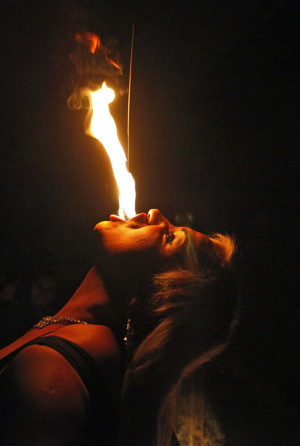In this July 7, 2013 photo, drag queen Susan Brown spits fire during her performance in the "Fama" circus show in Santiago, Chile.  The only classic circus act in Fama is Brown's fire eating performance.  Fama has toured the country for more than a decade performing in modest tents and they say their show remains a refuge from discrimination. Chile has traditionally been a tough place for homosexuals. (AP Photo/Luis Hidalgo)